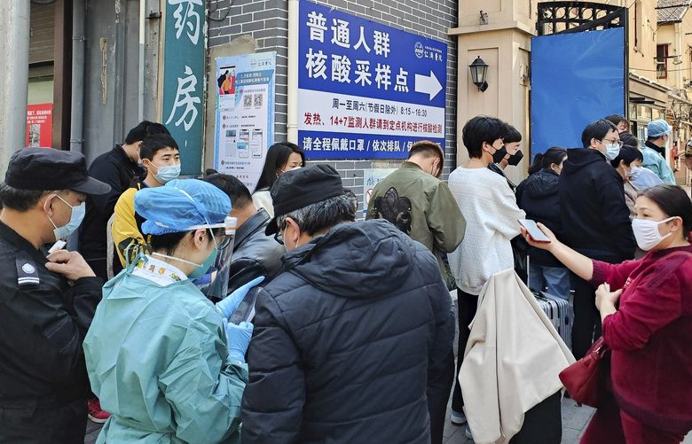 People line up for coronavirus tests outside a hospital in Shanghai, Friday, March 11, 2022. China has ordered a lockdown of the 9 million residents of the northeastern city of Changchun amid a new spike in COVID-19 cases in the area. (Chinatopix via AP) XMAS801 XMAS801