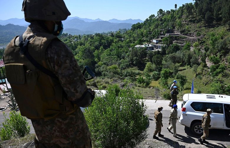 A Pakistani soldier stands guard on a post as a vehicle carrying UN military observers arrives to visit near the Line of Control, de facto border between India and Pakistan at Salohi village in Poonch district of Pakistan-administered Kashmir on April 26, 2021. (Aamir Qureshi/AFP via Getty Images/TNS) 42358045W 42358045W