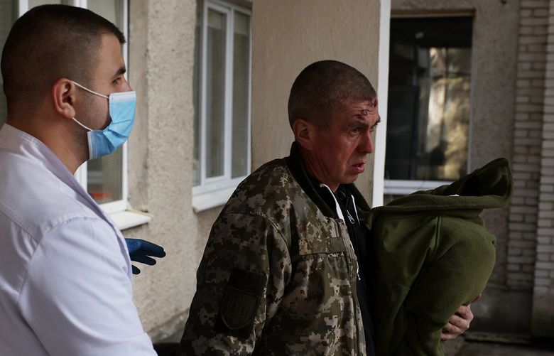 A man wounded in this morning’s air strikes at a nearby military complex is assisted by medical staff outside Novoiavorivsk District Hospital on Sunday, March 13, 2022 in Novoiavorivsk, Ukraine. Early this morning, a series of Russian missiles struck the International Center for Peacekeeping and Security at the nearby Yavoriv military complex, killing at least 35 and wounding scores, according to Ukrainian officials. The site is west of Lviv and mere miles from Ukraine’s border with Poland, a NATO member. (Dan Kitwood/Getty Images/TNS) 42522992W 42522992W