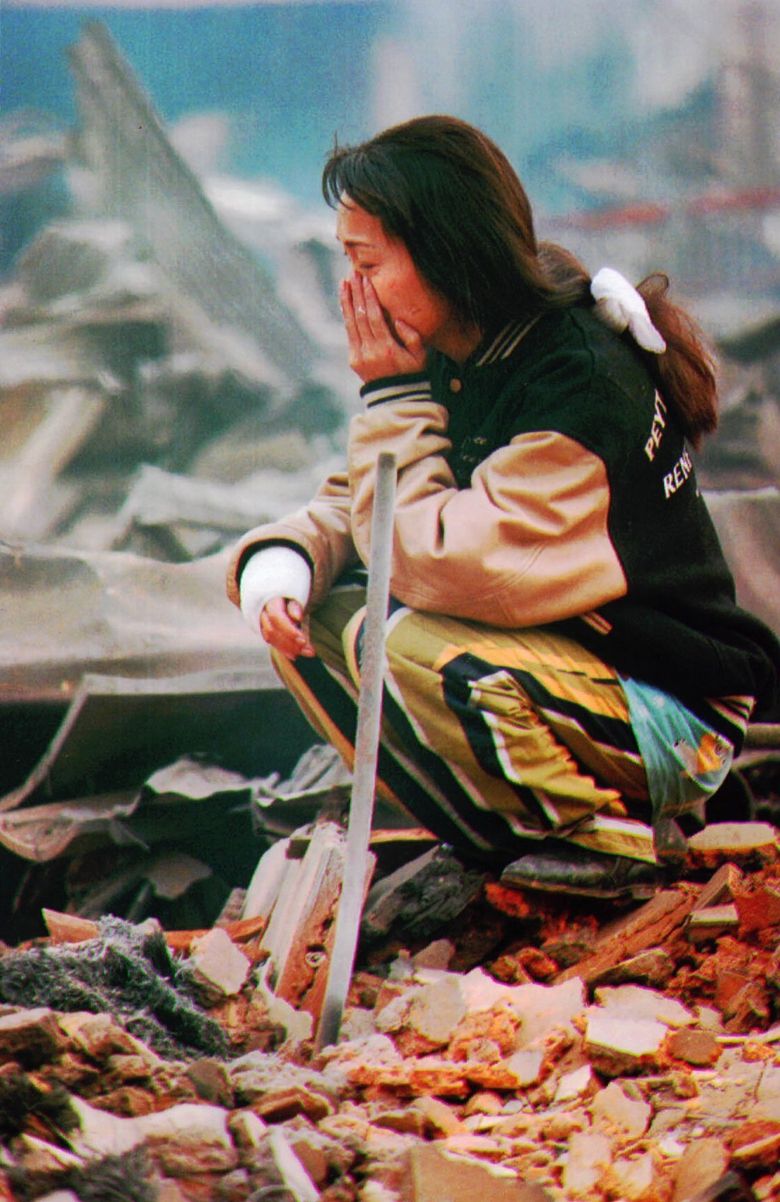 A woman sits among the rubble of her house in Kobe, Japan, a day after an earthquake devastated the city in 1995. (The Associated Press, 1995)