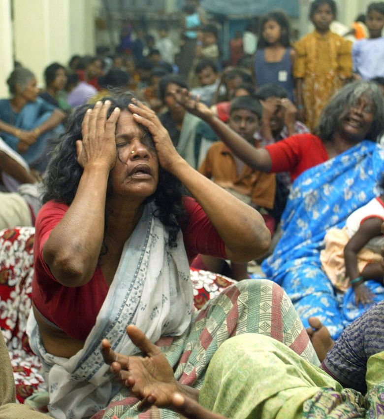 People displaced by a tsunami mourn their losses at a relief camp at a temple in India in 2004. An earthquake that started deep beneath the Indian Ocean generated a significant tsunami. More than 225,000 people died in 14 countries as a result. (Gurinder Osan / The Associated Press, 2004)
