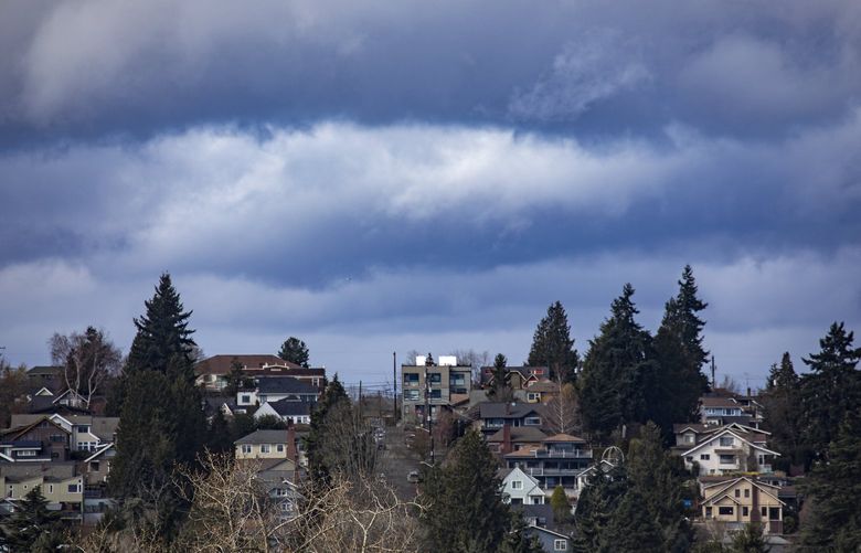 Intense cloud patterns form behind Phinney Ridge homes, Sunday, March 13, 2022 in Seattle. Forecasters say a mild atmospheric river or a “good frontal system” are expected to reach the Puget Sound region sometime Monday and last through midweek. 219847