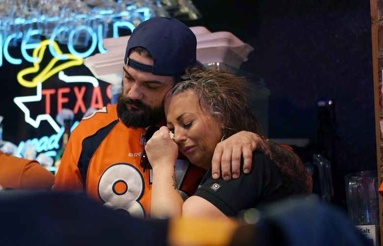 Erik Herring, center left, and Andera Concotelli console each other during a memorial for Jackson Zinn at a Texas Roadhouse restaurant, Thursday, March 17, 2022, in Hobbs, New Mexico. Zinn, who worked at the restaurant, was killed with several other student golfers and the coach of University of the Southwest in a crash in Texas. (AP Photo/John Locher) NMJL115 NMJL115