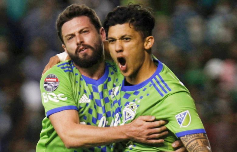 Fredy Montero, right, of the Seattle Sounders celebrates with Joao Paulo Mior, his side’s opening goal against Mexico’s Leon during a CONCACAF Champions League soccer match in Leon, Mexico, Thursday. (Mario Armas / AP)