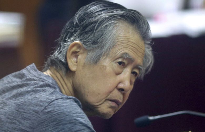 FILE – Jailed former Peruvian President Alberto Fujimori, photographed through a glass window, attends his trial at a police base on the outskirts of Lima, Peru, April 23, 2014. Peru’s Constitutional Court on Thursday, March 17, 2022, approved the release from prison of Fujimori, who is serving a 25-year sentence for murder and corruption charges. (AP Photo/Martin Mejia, File) XLAT115 XLAT115