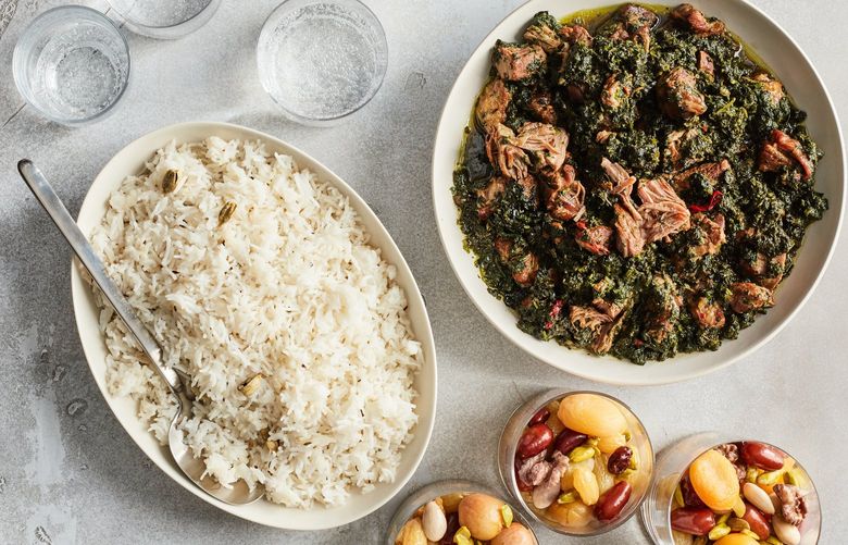 A Nowruz feast of sabzi challaw, a fragrant spinach and lamb stew with rice, and haft mewa, a nut and dried fruit compote, in New York, March 1, 2022. The holiday marks the beginning of spring, with many in the diaspora celebrating with rebirth, renewal and, now, resistance in mind. Food styled by Rebecca Jurkevich. (Johnny Miller/The New York Times) XNYT29 XNYT29