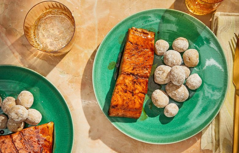 Whiskey-glazed salmon with salt-crusted potatoes, in New York, Jan. 31, 2022. A simple dinner, which Genevieve Ko created for her college-bound daughter, also yielded a smart trick for silky, scentless fish. Props styled by Paige Hicks. Food styled by Monica Pierini. (Jenny Huang/The New York Times) XNYT51 XNYT51