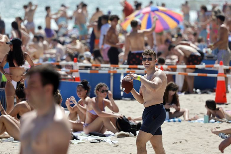 本月早些时候，俄亥俄大学大三学生丹·菲尼齐奥在佛罗里达州一个拥挤的劳德代尔堡海滩上踢足球。 （Amy Beth Bennett / South Florida Sun-Sentinel，来自美联社）