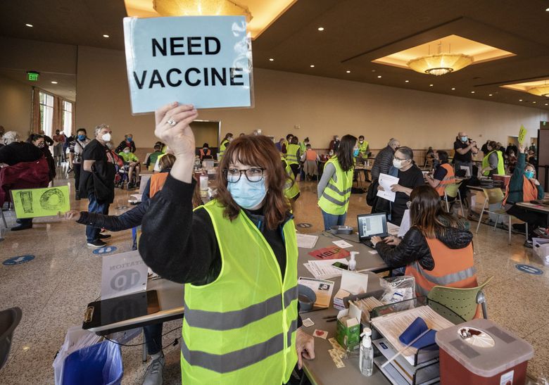 工人于 2021 年 1 月在西雅图大学开设了一家疫苗接种诊所。 随着华盛顿进入冠状病毒大流行的第三个年头，该州制定了下一阶段的计划。 （史蒂夫·林曼 / 西雅图时报）