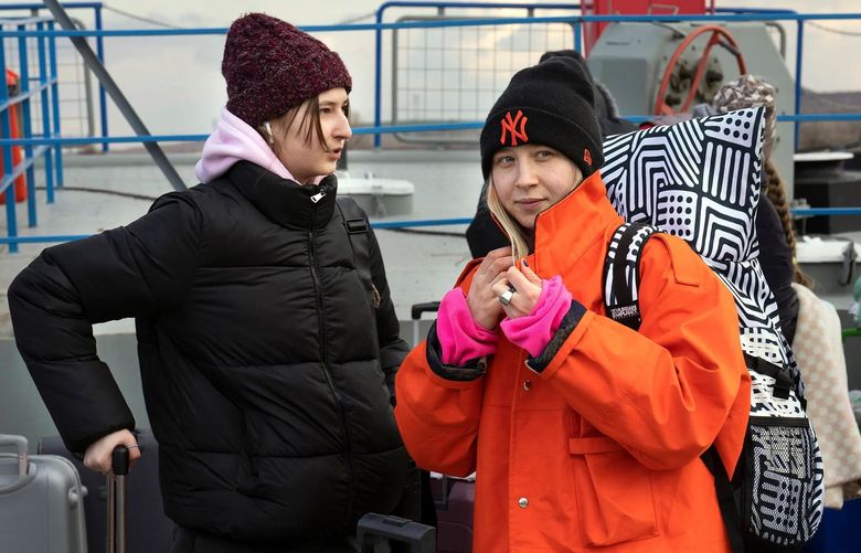 FILE —Nastya Filipas, right, who fled Odessa, Ukraine, with her younger sister, Viktoryia, left, in Bucharest, Romania, March 10, 2022. Job boards are overflowing with offers dedicated to Ukrainian refugees, as businesses and governments fast-track access to employment.