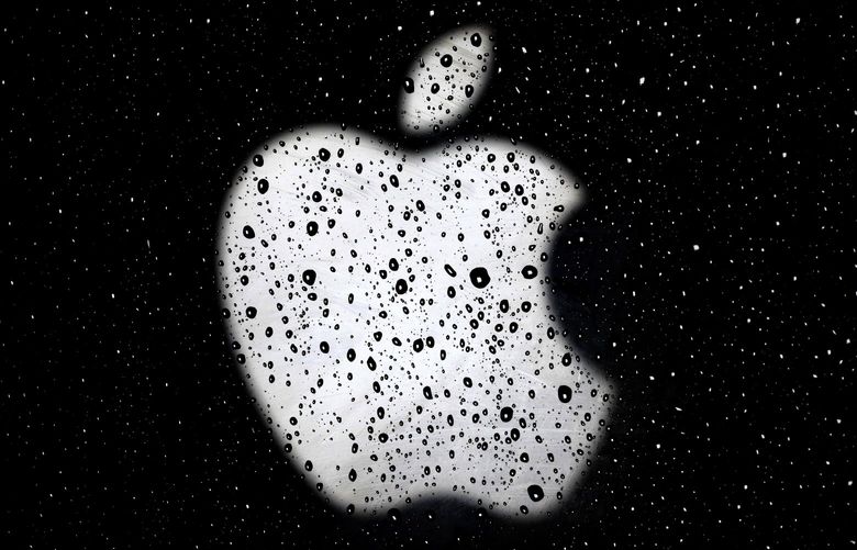 FILE – An Apple logo is seen in raindrops on a window outside an Apple Store at the Country Club Plaza shopping district in Kansas City, Mo., on Dec. 26, 2018. A former Apple employee has been charged with defrauding the tech giant out of more than $10 million by taking kickbacks, stealing equipment and laundering money. Federal prosecutors say they filed charges Friday, March 18, 2022, against Dhirendra Prasad.   (AP Photo/Charlie Riedel, File) LA601 LA601