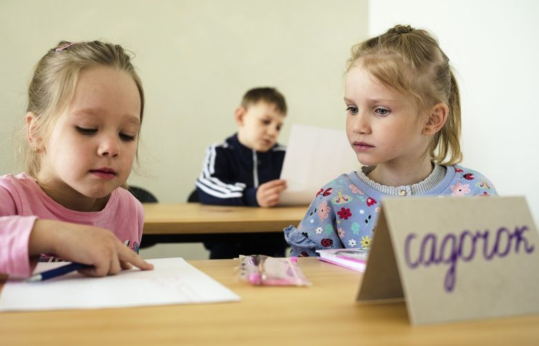 Two children attend a class for refugees from the Ukraine in Berlin, Germany, Monday, March 21, 2022. Forty Ukrainian refugee children started their first day of elementary school in Berlin on Monday only weeks after they fled the war back home. The two private refugee classes were put together by two Berlin volunteers who managed to raise funds, get free class rooms. (AP Photo/Markus Schreiber) MSC105 MSC105