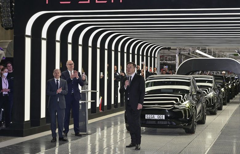 German Chancellor Olaf Scholz, Dietmar Woidke, Minister President of the State of Brandenburg, and Elon Musk, Tesla CEO, from left, attend the opening of the Tesla factory Berlin Brandenburg in Gruenheide, Germany, Tuesday, March 22, 2022. The first European factory in Gr’nheide, designed for 500,000 vehicles per year, is an important pillar of Tesla’s future strategy. (Patrick Pleul/Pool via AP) DMME135 DMME135