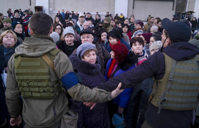 Ukrainian security forces stand guard as people crowd to board an evacuation train in Odesa, Ukraine, March 15, 2022. Three European leaders headed to Kyiv on Tuesday to express the European Union’s “unequivocal support” and offer financial aid to Ukraine, a dramatic visit that comes as intense fighting rages around the Ukrainian capital. XNYT67