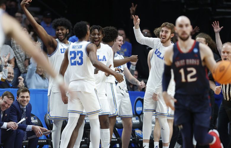UCLA players, including guard Peyton Watson (23) celebrate a 3-point basket against St. Mary’s late in the second half of a second-round NCAA college basketball tournament game, Saturday, March 19, 2022, in Portland, Ore. UCLA won 72-56. (AP Photo/Craig Mitchelldyer) WATW151 WATW151