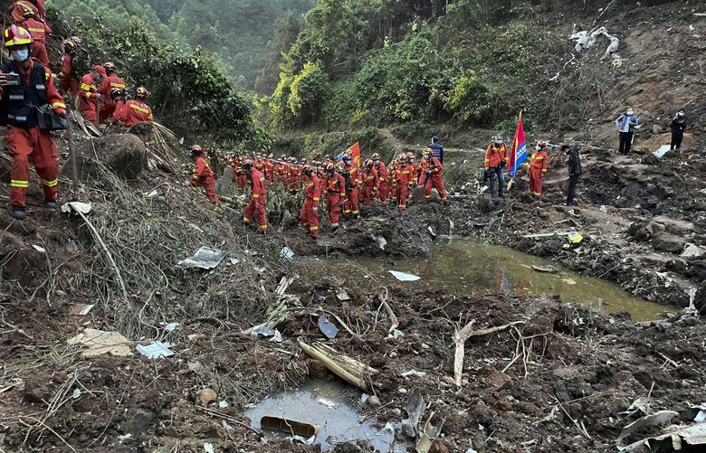 In this photo released by Xinhua News Agency, rescuers conduct search operations at the site of a plane crash in Tengxian County in southern China’s Guangxi Zhuang Autonomous Region, Tuesday, March 22, 2022. Mud-stained wallets. Bank cards. Official identity cards. Some of the personal effects of 132 lives presumed lost were lined up by rescue workers scouring a remote mountainside Tuesday for the wreckage of a China Eastern plane that one day earlier inexplicably fell from the sky and burst into a huge fireball. (Zhou Hua/Xinhua via AP) XIN802 XIN802