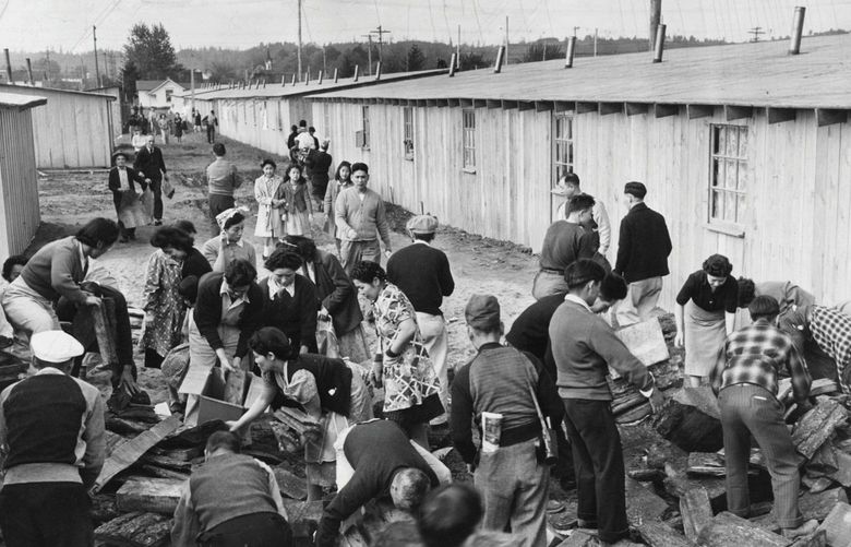 Japanese internment camp

seattle times centennial: 1940’S : DESPITE DISCRIMINATION, JAPANESE COMMUNITY BLOOMS – ONLY TO WITHER WITH WAR : CAMP HARMONY, AT THE PUYALLUP FAIRGROUNDS, WAS A TEMPORARY DETENTION CENTER FOR JAPANESE “EVACUEES” ON THEIR WAY TO CAMPS FARTHER INLAND. HERE, IN 1942, INTERNEES PICK UP FIREWOOD TO HEAT THEIR BARRACKS-STYLE LIVING QUARTERS.

Caption: Everybody works at the Puyallup camp for evacuated Japanese. Since all the camp’s stoves are wood burners, every family has developed a tremendous interest in wood deliveries made at street ends in trucks. A volunteer wood detail unloads the truck, but after htat its every man (and woman) for himself. Other volunteer detail work on camp’s streets and handle baggage of incoming evacuees.

Camp Harmony – Internment Camp at the Puyallup Fairgrounds

Photo originally taken: 5/7/1942
Photo published: 12/6/1971, 3/26/1980, 9/11/1981, 3/1/1983, 8/13/1985