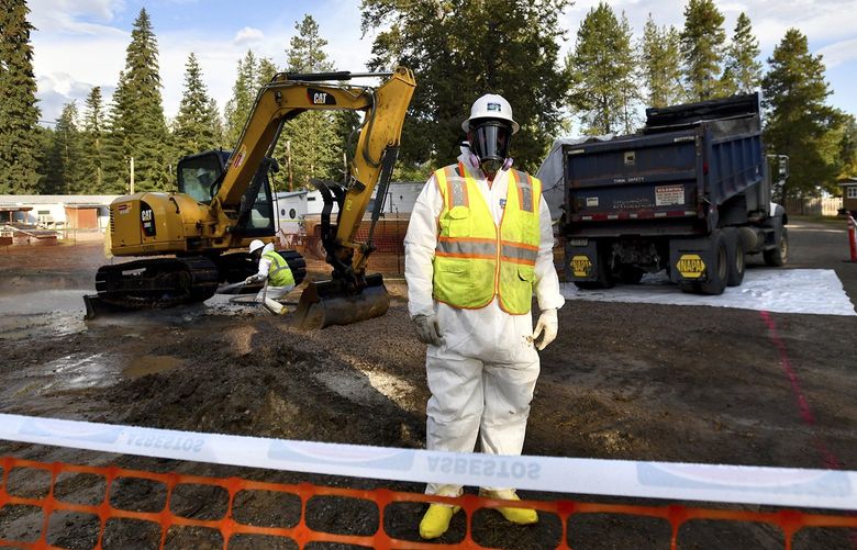 FILE – Environmental cleanup specialists work at an asbestos cleanup site in Libby, Montana, on September 13, 2018. U.S. regulators are moving to end a years-long environmental cleanup along 42 of miles of railroad in northwestern Montana that were contaminated by shipments of asbestos-containing vermiculite that was mined in the LIbby. (Kurt Wilson/The Missoulian via AP, File) MTMIS301 MTMIS301