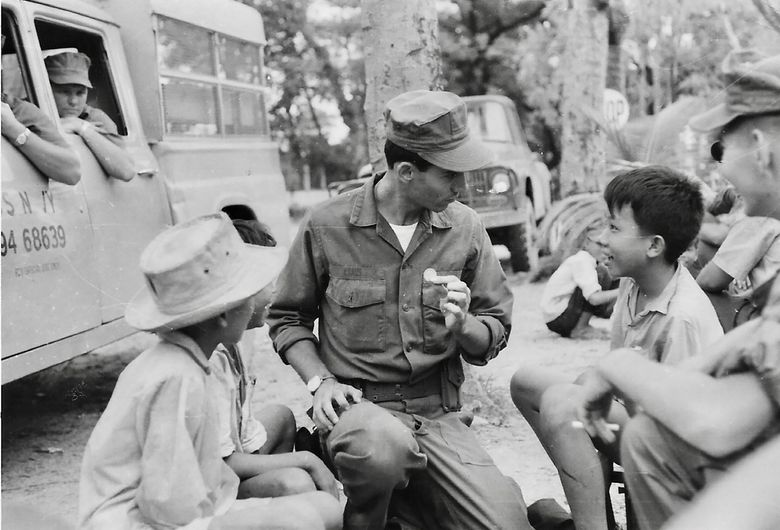 Charles Kraus entertains three young boys with one of his magic coin tricks in Da Nang, Vietnam, in 1967. (Courtesy of Charles Kraus)