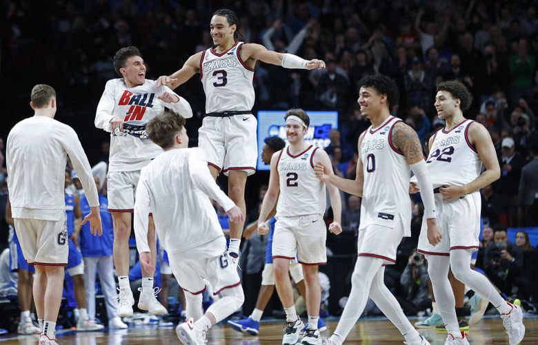 Gonzaga guard Andrew Nembhard (3) and forward Drew Timme (2) react with teammates after they beat Memphis 82-78 in a second-round NCAA college basketball tournament game, Saturday, March 19, 2022, in Portland, Ore. (AP Photo/Craig Mitchelldyer) WATW261 WATW261