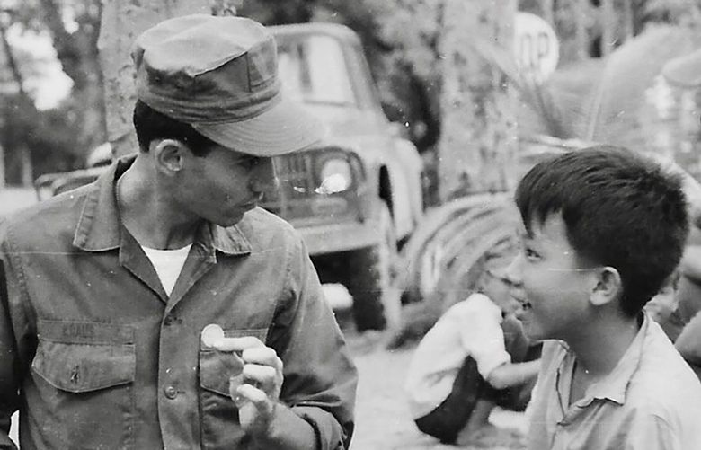 Charles Kraus entertains three young boys in Da Nang, Vietnam, in 1967 with one of his magic coin tricks.
