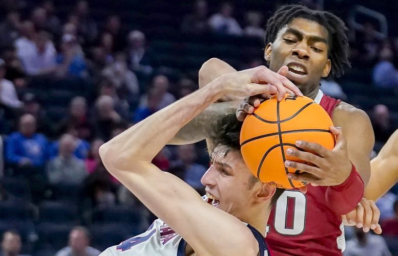 Arkansas forward Kamani Johnson, top, reaches for the ball over Gonzaga center Chet Holmgren during the first half of a college basketball game in the Sweet 16 round of the NCAA tournament in San Francisco, Thursday, March 24, 2022. (AP Photo/Marcio Jose Sanchez) CAJC112