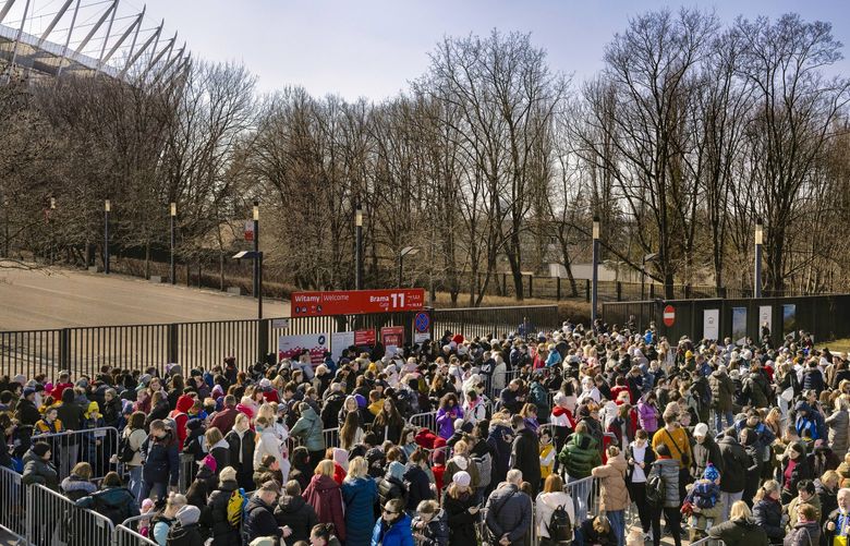 Hundreds of refugees from Ukraine wait in line at the National Stadium to receive Polish identification numbers, in Warsaw, Poland, March 21, 2022. The war has suddenly turned Poland and its right-wing populist government into the pivot around which many of the West’s hopes and Russia’s fury turn. (Maciek Nabrdalik/The New York Times) XNYT92