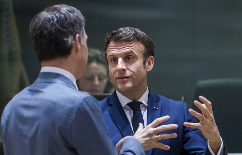Belgium’s Prime Minister Alexander De Croo, left, speaks with French President Emmanuel Macron during a round table meeting at an EU summit in Brussels, Friday, March 25, 2022. EU leaders struggled for hours Friday to find a compromise on a deal aimed at curbing energy prices that have gone through the roof and hurt households and businesses across the 27-nation bloc. (AP Photo/Geert Vanden Wijngaert) VLM173 VLM173