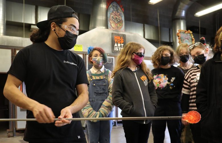 Artist, instructor and alum of this hot shop, Trenton Quiocho demonstrates how to handle this hot glass to Hilltop Heritage Middle Schoolers and how to shape it.

 Wednesday March 16, 2022 219869