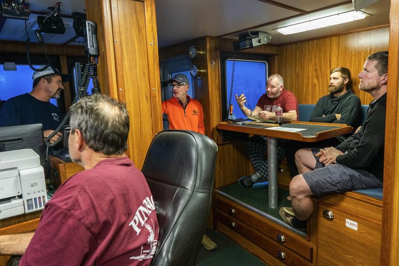Mike Grant, with radio, practices making a mayday call as part of a safety briefing Jan. 16 aboard the Pinnacle in the Bering Sea. From left, Capt. Mark Casto, first mate Eben Brown, David Lethin, Grant, Jack Bunnell and Jerret Kummer. (Loren Holmes / Anchorage Daily News) 