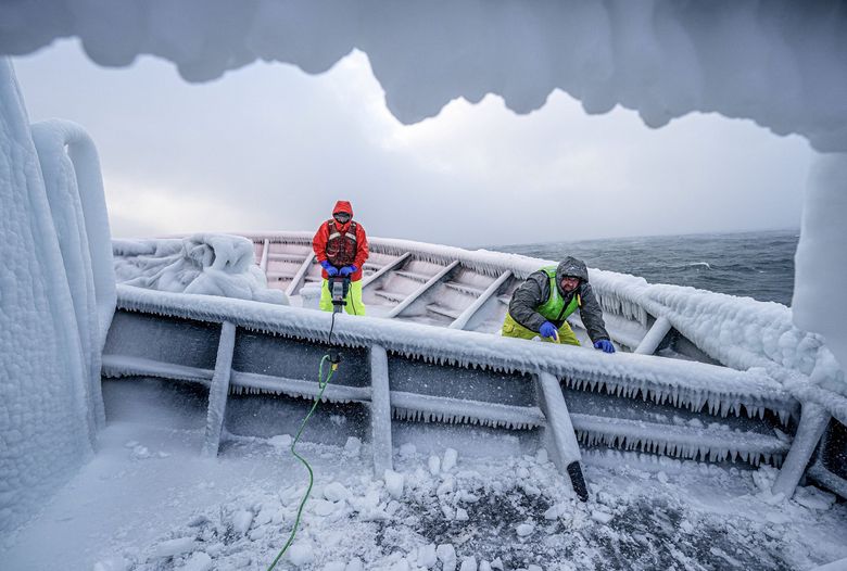 Crewman Jack Bunnell, left, uses a jackhammer to clear ice from the bow of the fishing boat Pinnacle, as his fellow crewman Dan Jacobson shovels the ice chunks overboard on Jan. 19. Freezing spray can build up on fishing boats, adding significant weight and changing the stability of the vessel, potentially causing it to capsize. (Loren Holmes / Anchorage Daily News) 