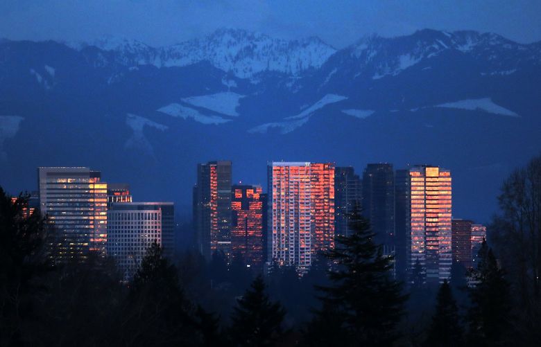 The Bellevue skyline is aglow at sundown; viewed from Seattle, Monday, Mar. 1, 2021. Jon Talton writes about how Bellevue and Seattle fortunes are intertwined — they’re complementary, but they’re also competitors, and there have been good times and bad for both. 219061