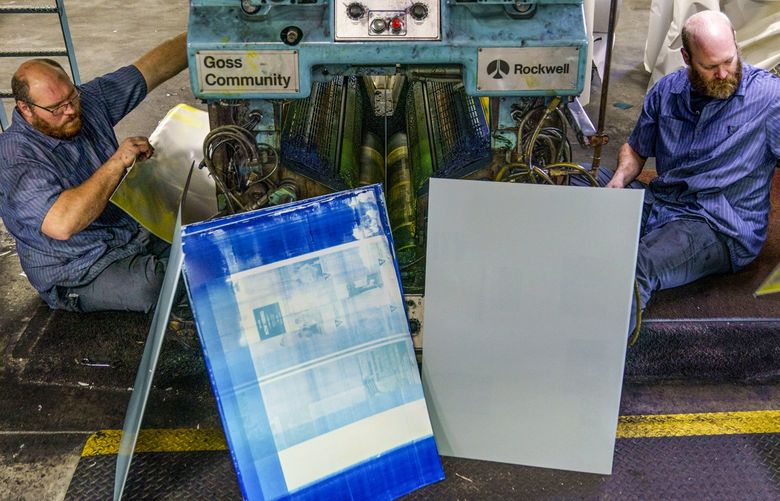 Pressmen Matt Chan, left, and Todd Grewe prepare to print the latest edition of The Swift County Monitor-News at Quinco Press in Lowry, Minn., Tuesday, Nov. 30, 2021.