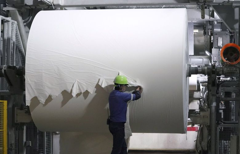 A worker checks a spool of recycled paper on the toilet paper production line at a Corelex Shinei Co. factory in Fuji, Shizuoka Prefecture, Japan, on Sept. 7, 2021.