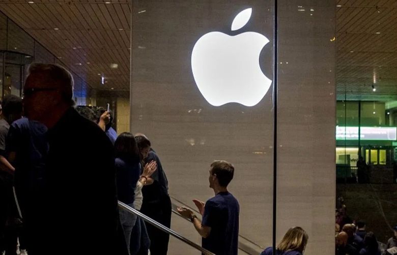 An Apple logo is illuminated as customers walk through the new Apple Inc. Michigan Avenue store during the store’s opening in Chicago, in 2017.