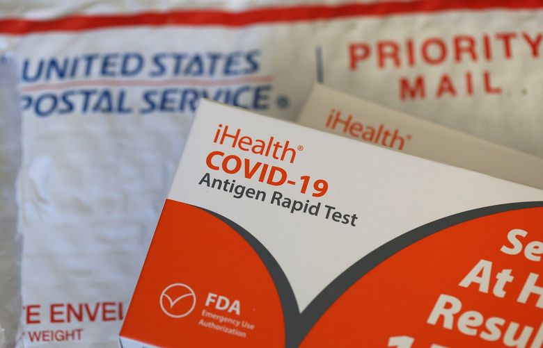 In this photo illustration, free iHealth COVID-19 antigen rapid tests from the federal government sit on a U.S. Postal Service envelope after being delivered on Feb. 4, 2022, in San Anselmo, California. (Justin Sullivan/Getty Images/TNS) 43941554W 43941554W