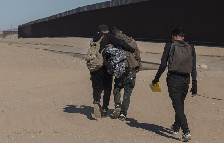 FILE – Nicaraguan migrants walk on the US-Mexico border, in Algodones, Baja California, Mexico, Dec. 2, 2021. The group walked into the U.S. and turned themselves over to the border patrol asking for asylum. The Biden administration has a draft plan to end sweeping asylum limits at the U.S.-Mexico border by May 23 that were put in place to prevent the spread of COVID-19, according to people familiar with the plans. (AP Photo/Felix Marquez, File) WX101 WX101