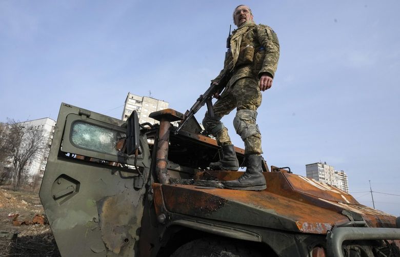 A Ukrainian soldier stands a top a destroyed Russian APC after recent battle in Kharkiv, Ukraine, Saturday, March 26, 2022. With Russia continuing to strike and encircle urban populations, from Chernihiv and Kharkiv in the north to Mariupol in the south, Ukrainian authorities said Saturday that they cannot trust statements from the Russian military Friday suggesting that the Kremlin planned to concentrate its remaining strength on wresting the entirety of Ukraine’s eastern Donbas region from Ukrainian control. (AP Photo/Efrem Lukatsky) XEL101 XEL101