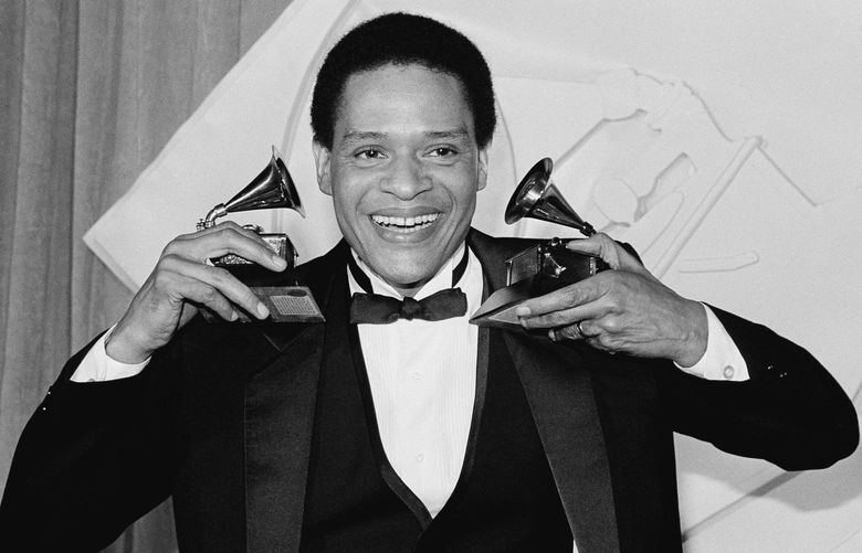Singer Al Jarreau has more than an earful as he holds up his Grammy he won during the 24th annual Grammy Awards presentation in Los Angeles Wednesday night, Feb. 25, 1982. Jarreau won the honors for best pop male vocalist and best jazz male vocalist. (AP Photo/Reed Saxon)