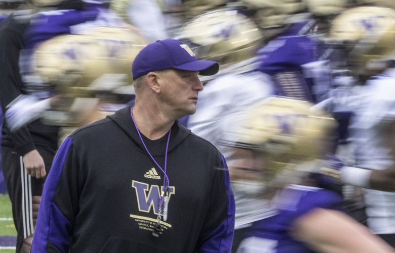 Wed. March 30, 2022.  First UW football spring practice.   UW coach Kalen Deboer walking among players and staff s they perform early morning warmups.   219945
