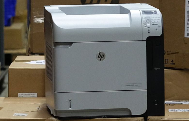 An employee unpacks a HP desktop computer, produced by Hewlett-Packard Co., alongside a HP laserjet printer, in a warehouse in this arranged photograph taken in London, U.K., on Monday, Oct. 6, 2014. Hewlett-Packard Co. unveiled plans to split into two companies, becoming the latest technology company to seek a new structure in order to remain competitive. Photographer: Simon Dawson/Bloomberg