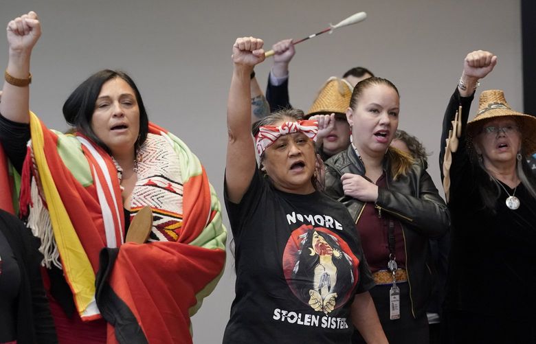 Monie Ordonia, second from left, of the Tulalip Indian Tribe, joins others in singing an honor song after Washington Gov. Jay Inslee signed a bill that creates a first-in-the-nation statewide alert system for missing Indigenous people — particularly women, Thursday, March 31, 2022, in Quil Ceda Village, near Marysville, Wash., north of Seattle. The law creates a system similar to Amber Alerts, which are used for missing children in many states. (AP Photo/Ted S. Warren) WATW203 WATW203