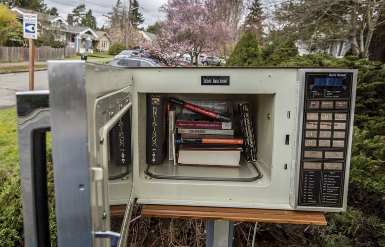 Sorry, you can’t heat up a frozen burrito, but books are available at a new free library contained in an old microwave oven, complete with a dummy electrical outlet, which has popped up along NE 65th St. in Ravenna and is turning heads, Sunday, March 20, 2022 in Seattle. Complete with a latched door, cooking instructions, and a plaque inside that reads “The Gladys L Memorial Microwave,” at top, the library is conveniently located by a new bus stop and crosswalk along NE 65th St. at 27th Ave. NE. 219914