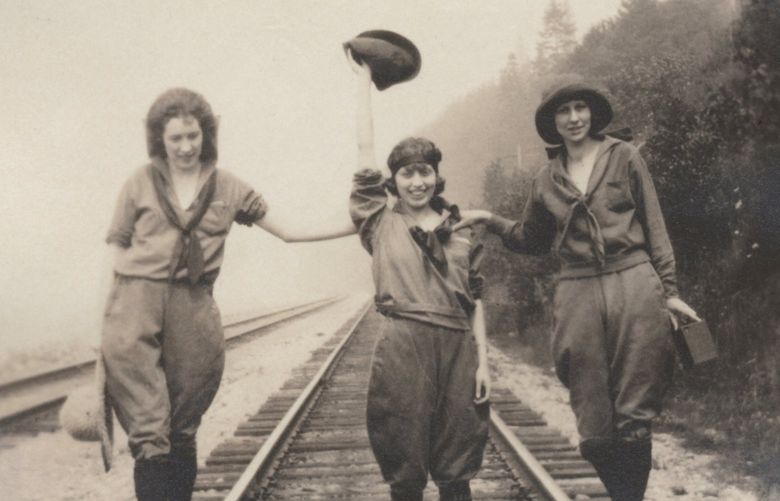 THEN: In the cover image of a new book, “Preserving Ballard,” three young women straddle a railroad track along Ballard’s west flank in the late 1910s or early 1920s. Two are Swedish sisters from the Peterson family: Rhoda, left, and Ethel, center. The third is believed to have been their friend. A younger sibling, Ted Peterson, became a state senator and during his retirement led a successful campaign to restore the Ballard Bell to its original position on Ballard Avenue.
Credit: Peterson Collection / Ballard Historical Society