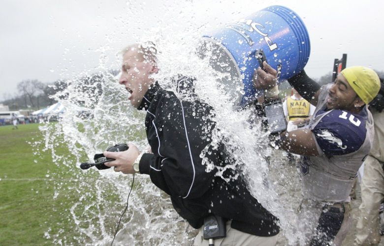 Sioux Falls head coach Kalen DeBoer is dunked on the sidelines by quarterback Lorenzo Brown (10) during the the closing moments of the NAIA National Championship football game against Carroll college, Saturday Dec. 20, 2008, 2008, in Rome, Ga. Sioux Falls won 23-7. (AP Photo/John Amis)