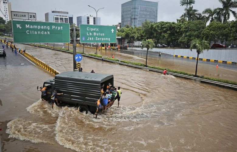FILE – A military truck drives through the water on a flooded toll road following heavy rains in Jakarta, Indonesia, Saturday, Feb. 20, 2021. A United Nations Intergovernmental Panel on Climate Change report released on Monday, Feb. 28, 2022, says a staggering 143 million people will be uprooted over the next 30 years by rising seas, searing temperatures and other climate calamities. (AP Photo/Dita Alangkara, File) NY601 NY601