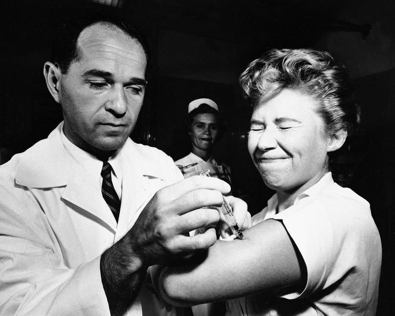 Joseph Ballinger 博士于 1957 年 8 月 16 日为纽约 Montefiore 医院的护士 Marjorie Hill 注射了第一针流感疫苗。（美联社照片/文件）
