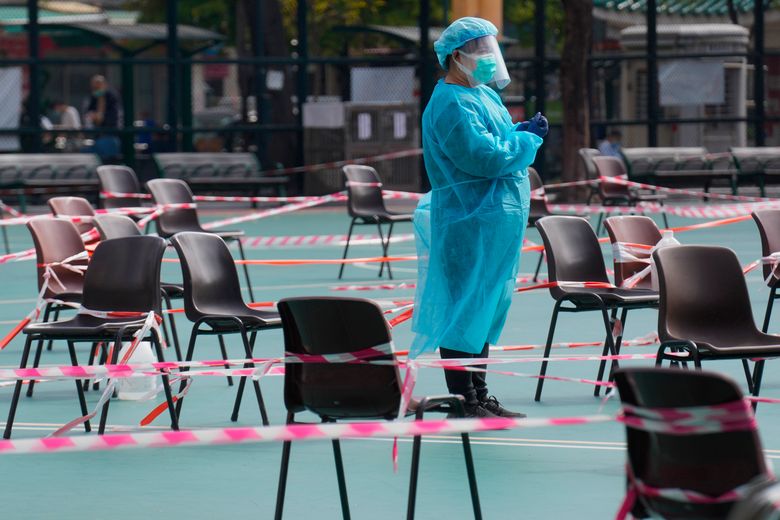 2022 年 2 月 28 日星期一，一名身穿防护装备的卫生工作者在香港的一个临时检测中心等待居民接受冠状病毒检测。（美联社照片/Vincent Yu）