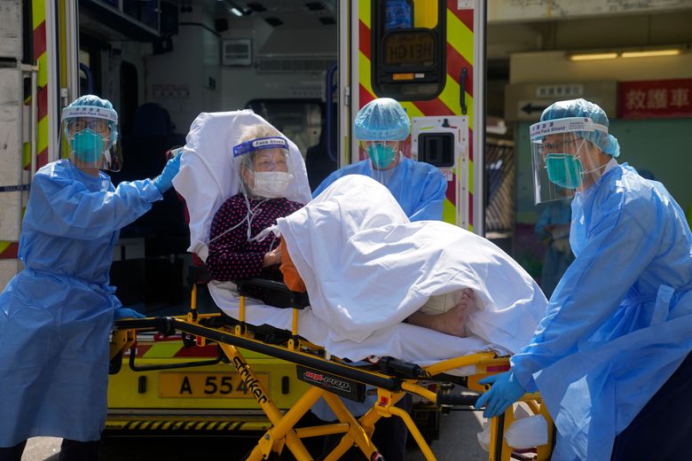 文件——2022 年 3 月 4 日，星期五，香港，身穿防护装备的医务人员将一名老年患者从救护车转移到医院。2022 年 3 月 18 日星期五，香港的冠状病毒感染总数超过 100 万，因为疫情广泛爆发，数千人最近几周的死亡人数。 （美联社照片/Kin Cheung，档案）