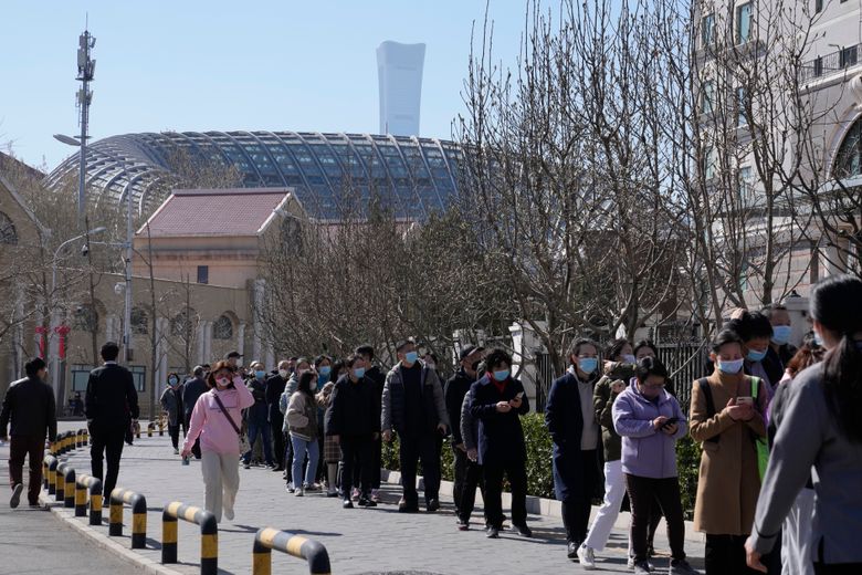 居民于 2022 年 3 月 14 日星期一在北京排队接受新冠病毒检测。 中国当局周一在数十个大陆城市报告了 1,300 多例本地传播的 COVID-19 病例，因为这种通常被称为“隐形 omicron”的快速传播变体助长了中国两年来最大的疫情。 （美联社照片/吴汉冠）